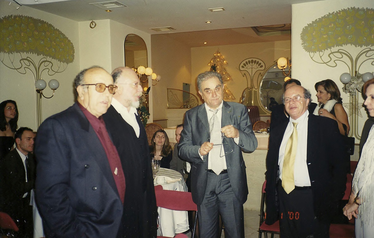 Στο κέντρο ο Σεραφείμ Φυντανίδης, δεξιά του ο Διονύσης Σαββόπουλος, αριστερά του ο μοναδικός Κύρ, δίπλα από τον Σαββόπουλο η ταπεινότητά μου, ψέλνουμε τα κάλαντα αφού έχει ήδη μπεί ο νέος χρόνος. Πίσω διακρίνεται η γιατρός Μαρίνα Λαλιώτη δίπλα στον σύζυγό της Κώστα Λαλιώτη και η δημοσιογράφος Εύη Κυριακοπούλου. 